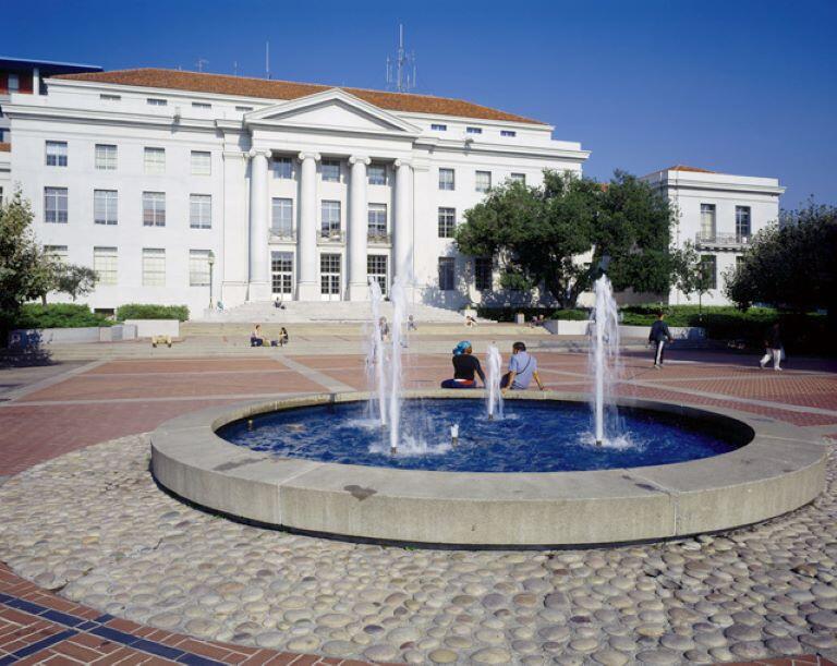 Ludwig's fountain in foreground, Sproul Hall and Sproul Plaza in the background, with some people walking and sitting