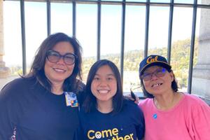 three people standing together wearing cal gear and smiling