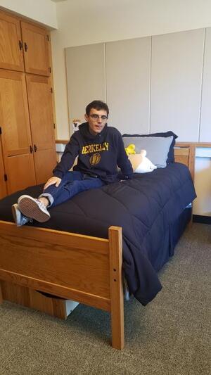 Ethan sitting on dorm bed