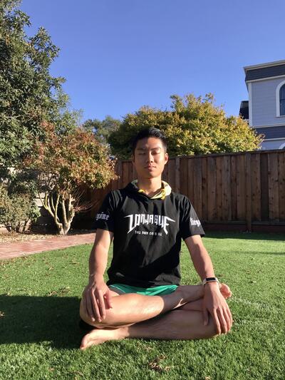 student meditating in a sunny backyard 